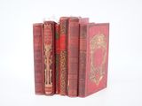 trois livres rouges superposés sur une surface blanche