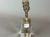 an image of a small bronze figurine of a man with a hat on his head