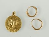 deux bagues en or et une pièce d'or sur laquelle est représenté le visage d'une femme