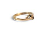 a close up of a gold ring with black and white diamonds