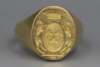 une image représentant une bague en or sur laquelle figure un blason