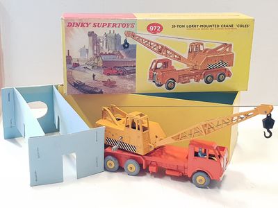 un camion-jouet équipé d'une grue, à côté d'une boîte