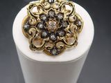 a close up of a gold and diamond ring on top of a white box