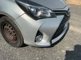 a close up of a silver car parked on the side of the road