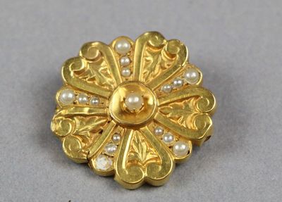 une photo en gros plan d'une broche ornée de perles