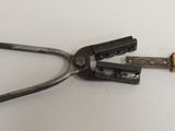a pair of pliers on a table with a piece of wood