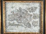 une vieille carte du monde est exposée dans un cadre doré
