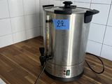 a stainless steel coffee pot sitting on a wooden counter