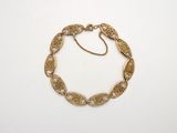 une image d'un bracelet en or sur fond blanc