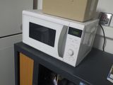 un micro-ondes posé sur un meuble, avec une boîte dessus