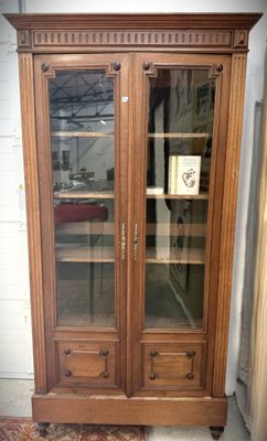 une armoire en bois avec des portes vitrées et un tapis au sol
