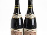 two bottles of wine sitting next to each other on a white surface