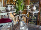 a silver candelab sitting on a glass table in a living room