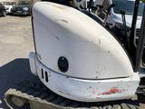 an image of a small white tractor parked in a parking lot