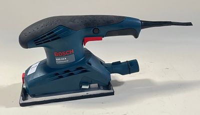 La ponceuse orbitale Bosch est posée sur une surface blanche
