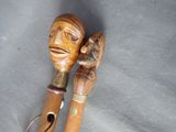 two wooden walking sticks with carvings on them on a gray surface