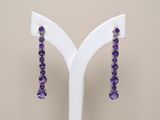 purple amethorate earrings on display on a white stand