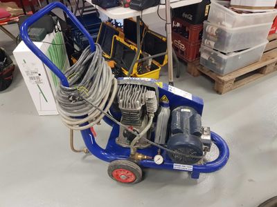 a blue cart with a hose on it in a warehouse