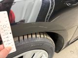 a person that is holding a sticker next to a car
