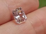 une personne tient un diamant rose dans la main, sur un fond vert