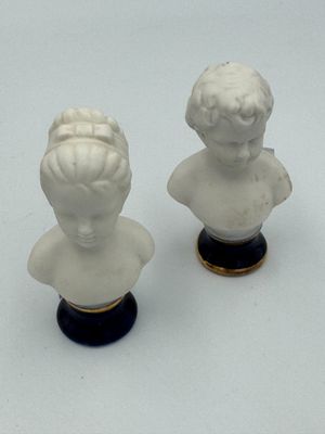deux figurines représentant un garçon et une fille assis sur une table