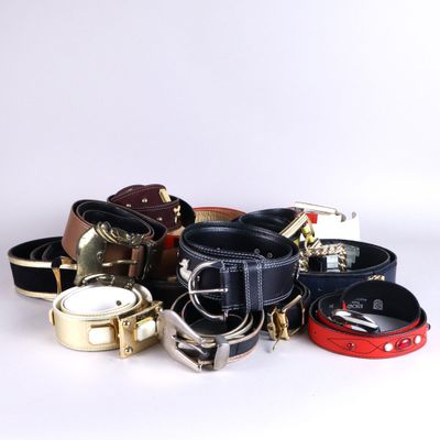 a lot of belts that are on a white surface