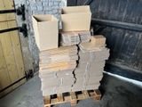 une pile de cartons posée sur une palette devant la porte d'un garage