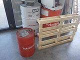 un fût rouge posé à côté d'une pile de fûts dans un garage