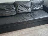a black leather couch in the corner of a room