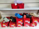 Plusieurs paires de Crocs sont alignées sur une étagère dans un magasin