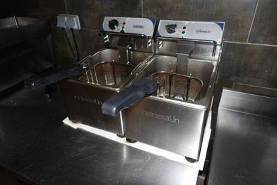 deux friteuses posées sur un plan de travail dans une cuisine
