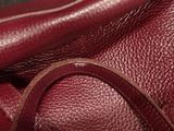 a close up of a red purse with a strap on it