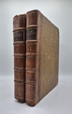deux vieux livres posés l'un sur l'autre sur une surface blanche
