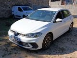 une voiture blanche garée devant un immeuble en briques