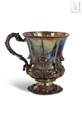 an antique silver cup with a dragon handle on a pedestal