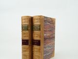 deux vieux livres posés l'un sur l'autre sur une surface blanche