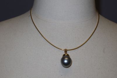 an image of a necklace with a black pearl on a mannequin