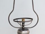 an old fashioned light fixture hanging from a chain on a white wall