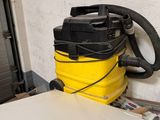 un aspirateur jaune et noir posé sur une table blanche