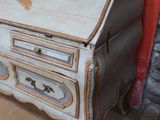 un petit bureau muni d'un tiroir, placé dans un coin de la pièce