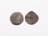 two silver coins on a white surface with a white background