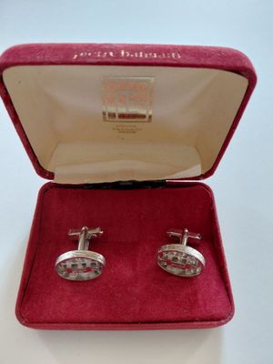 une paire de boutons de manchette dans un coffret en velours rouge doublé de velours rouge