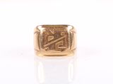 an image of a gold signet ring on a white surface