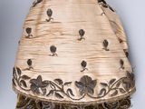 an image of a white and gold hat with a brown pom pom on it
