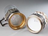 pair of silver and glass vases with gold rims on a white surface