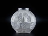 un vase en verre orné d'un motif sur un fond noir