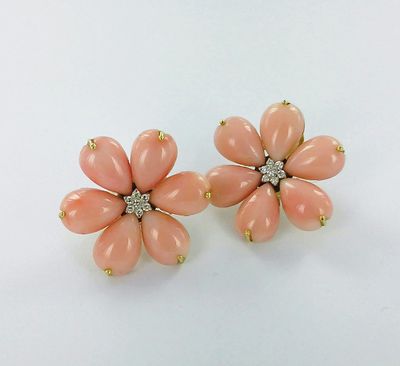 une paire de boucles d'oreilles en forme de fleur, de couleur corail, ornées de diamants