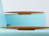 a surfboard sitting on top of a chair next to a table