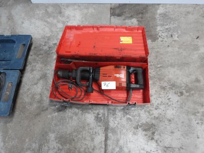 a red box with a drill in it sitting on the floor