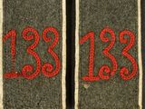 two green and red patches with numbers on them on a black surface